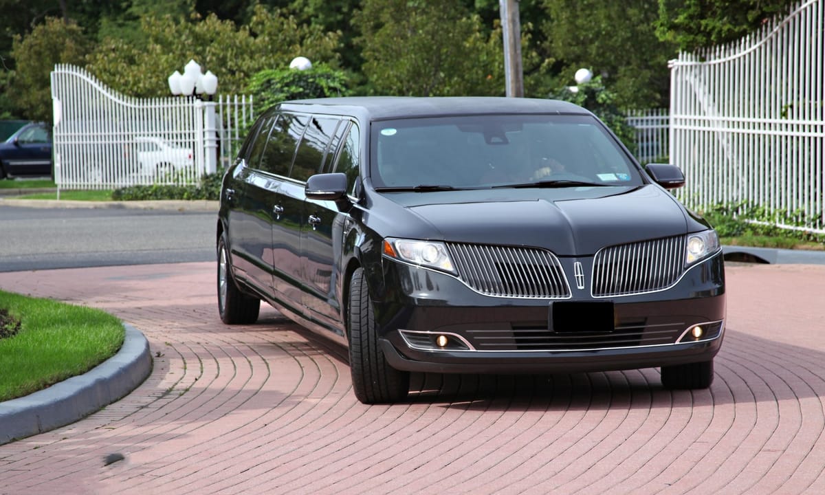 Black Lincoln MKT stretch limousine arriving at a private gated driveway